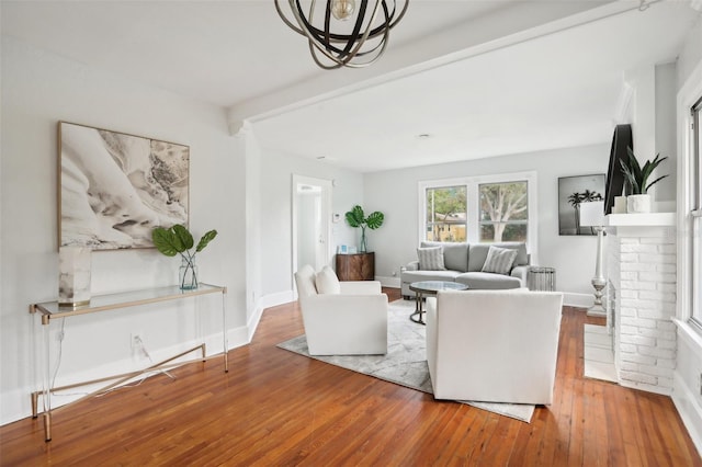 2015 3rd St S, Saint Petersburg, FL 33705 - living room featuring hardwood / wood-style flooring, baseboards, beamed ceiling, and a brick fireplace