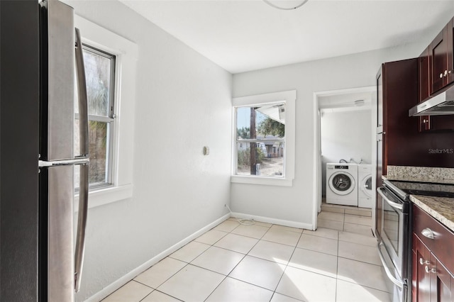 2015 3rd St S, Saint Petersburg, FL 33705 - kitchen featuring appliances with stainless steel finishes, separate washer and dryer, under cabinet range hood, baseboards, and light tile patterned floors