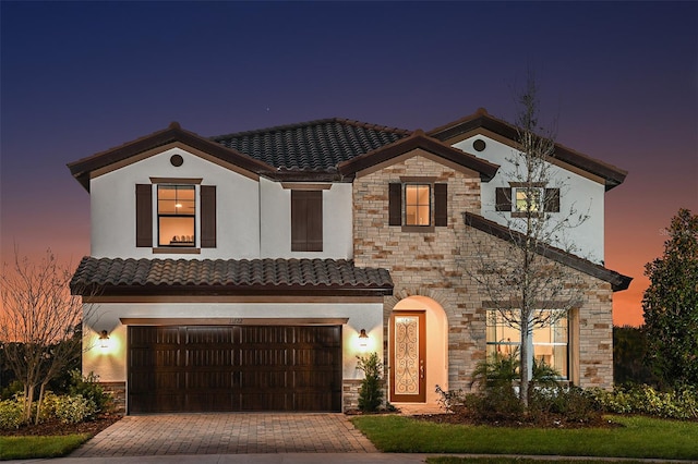 13722 Heartwood Way, Parrish, FL 34219 - mediterranean / spanish-style house featuring a tile roof, stone siding, stucco siding, and decorative driveway
