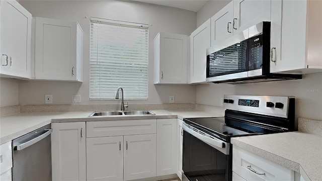 13640 Forest Lake Dr, Largo, FL 33771 - kitchen featuring appliances with stainless steel finishes, a sink, white cabinets, and light countertops