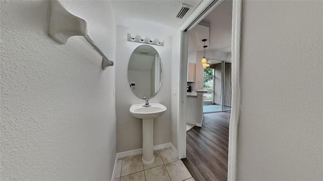 13640 Forest Lake Dr, Largo, FL 33771 - bathroom featuring tile patterned floors, a textured wall, baseboards, and a textured ceiling