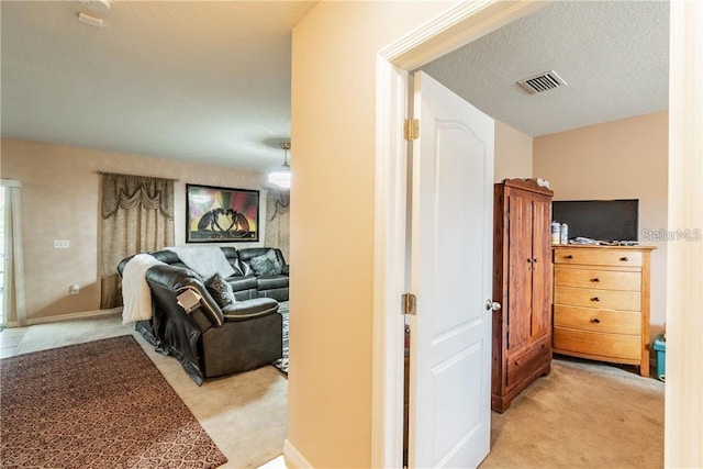 hallway featuring light colored carpet