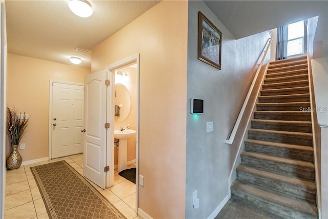 stairs featuring tile patterned floors and baseboards