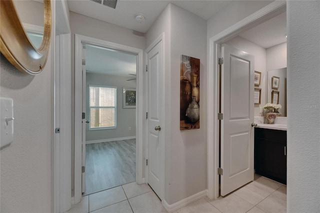 hallway with light tile patterned floors and baseboards