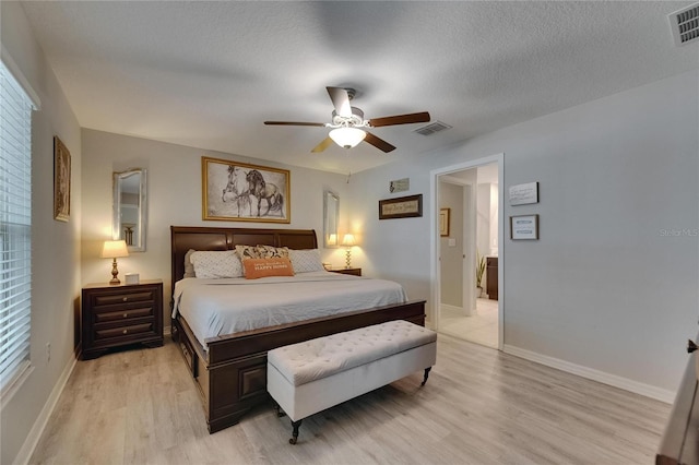 bedroom featuring light wood-type flooring, baseboards, a ceiling fan, and a textured ceiling