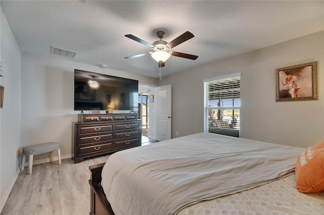 bedroom with light wood-style flooring, baseboards, ceiling fan, and a textured ceiling