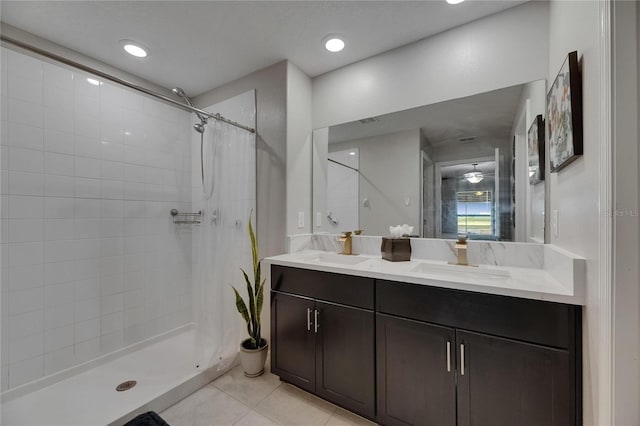bathroom featuring double vanity, a stall shower, and tile patterned floors