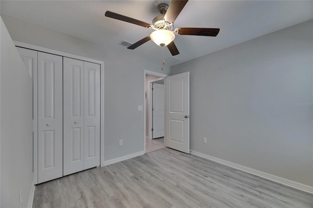 unfurnished bedroom featuring light wood-type flooring, baseboards, and a closet