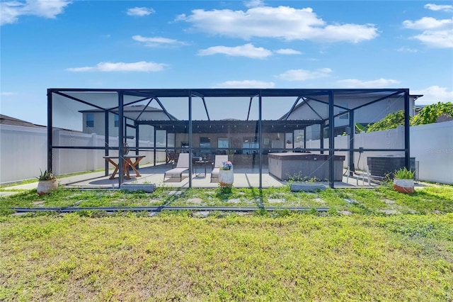 back of house featuring a hot tub, a patio area, cooling unit, and glass enclosure