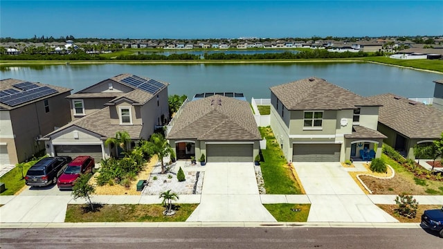 view of front of house featuring stucco siding, a water view, concrete driveway, a garage, and a residential view