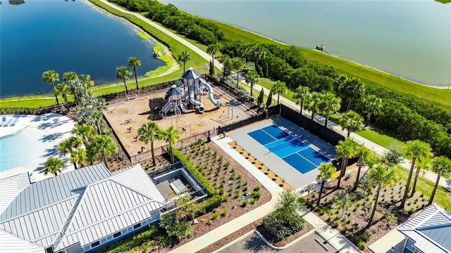 drone / aerial view of a pool area and a nearby body of water