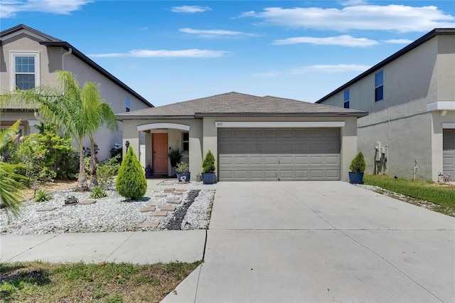 view of front facade with stucco siding, an attached garage, driveway, and roof with shingles