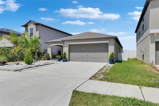 view of front of home with stucco siding, concrete driveway, a garage, and a front yard