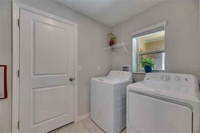 laundry area with washer and clothes dryer, light tile patterned floors, and baseboards
