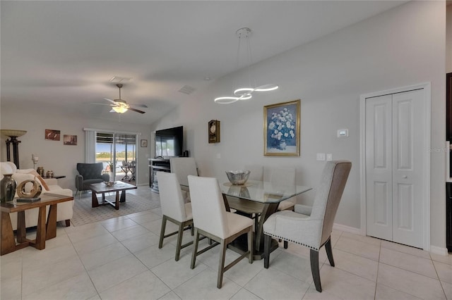dining room with vaulted ceiling, light tile patterned flooring, ceiling fan, a chandelier, and baseboards
