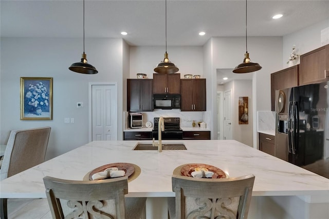 kitchen with black appliances, a sink, pendant lighting, a spacious island, and recessed lighting