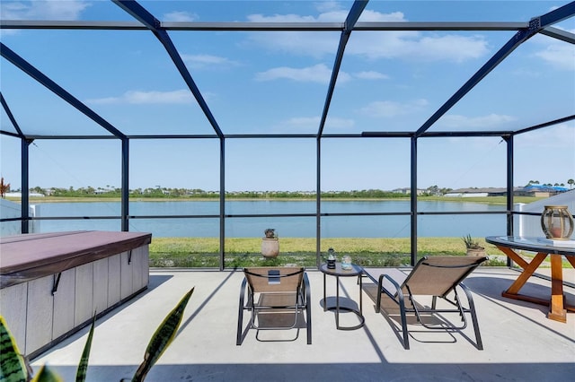 view of patio / terrace with a hot tub, a lanai, and a water view