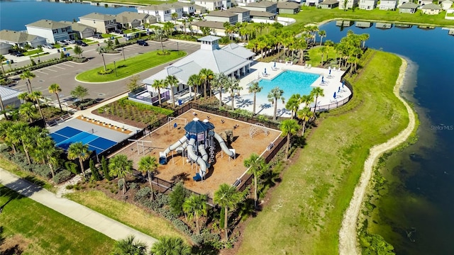 aerial perspective of suburban area with a nearby body of water and a pool