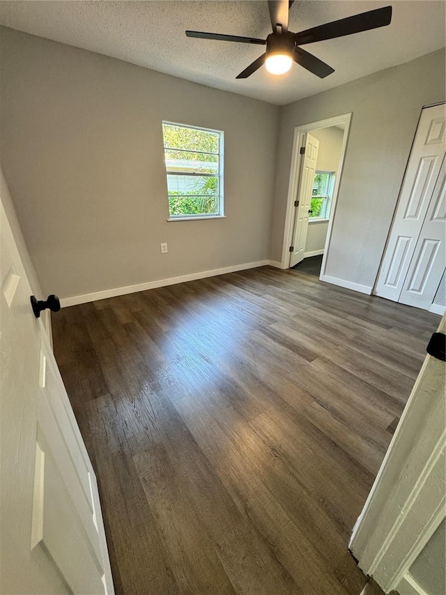 1675 13th Ave S, Saint Petersburg, FL 33712 - unfurnished bedroom with dark wood-style floors, baseboards, a ceiling fan, and a textured ceiling