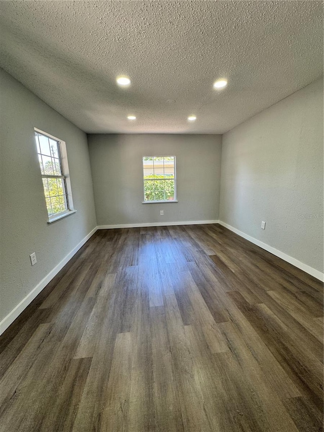1675 13th Ave S, Saint Petersburg, FL 33712 - empty room featuring plenty of natural light, dark wood-type flooring, a textured ceiling, recessed lighting, and baseboards