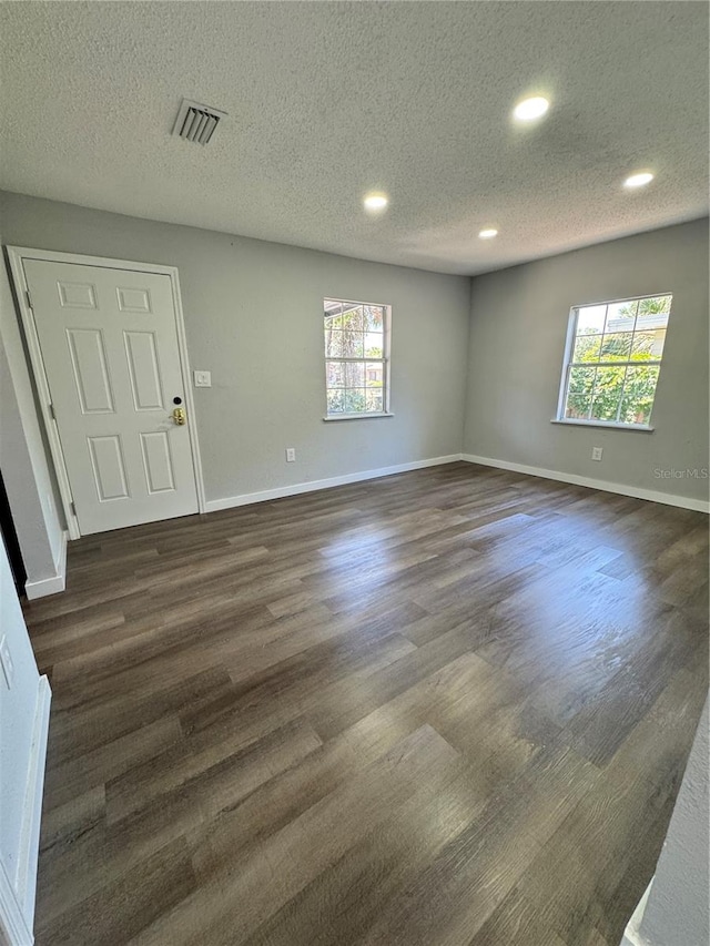 1675 13th Ave S, Saint Petersburg, FL 33712 - empty room with recessed lighting, dark wood-style floors, a textured ceiling, and baseboards