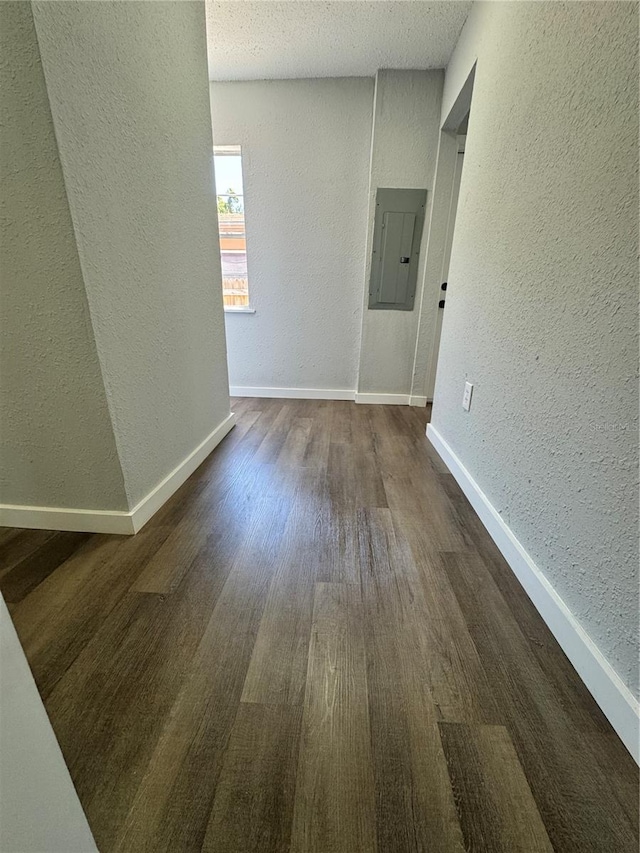 1675 13th Ave S, Saint Petersburg, FL 33712 - empty room featuring a textured wall, electric panel, dark wood-style flooring, and baseboards