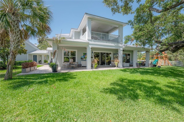 8927 Key W Island Way, Riverview, FL 33578 - rear view of property featuring a balcony, a patio, a yard, a standing seam roof, and a playground