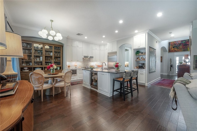 8927 Key W Island Way, Riverview, FL 33578 - kitchen with arched walkways, crown molding, open shelves, beverage cooler, and stainless steel built in fridge