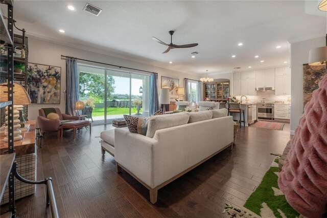 8927 Key W Island Way, Riverview, FL 33578 - living room with crown molding, recessed lighting, a ceiling fan, dark wood-type flooring, and a chandelier