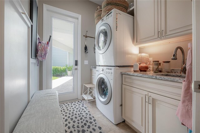 8927 Key W Island Way, Riverview, FL 33578 - laundry room featuring stacked washing machine and dryer, cabinet space, and light tile patterned floors