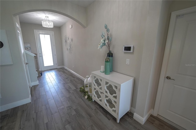 13103 Monach Isles Dr, Riverview, FL 33579 - entrance foyer with arched walkways, dark wood-style flooring, and baseboards