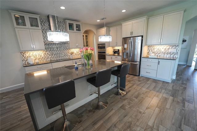 13103 Monach Isles Dr, Riverview, FL 33579 - kitchen featuring stainless steel appliances, wall chimney exhaust hood, backsplash, recessed lighting, and a kitchen island with sink