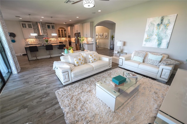 13103 Monach Isles Dr, Riverview, FL 33579 - living room with arched walkways, wood finished floors, a ceiling fan, recessed lighting, and baseboards