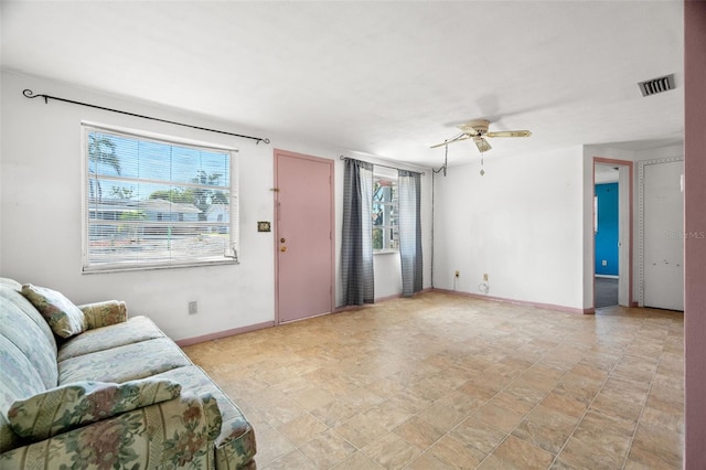 3348 Clydesdale Dr, Holiday, FL 34691 - living room featuring healthy amount of natural light, a ceiling fan, baseboards, and stone finish floors