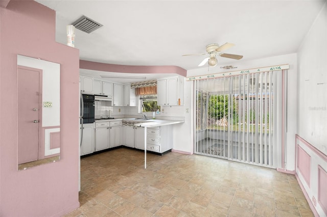 3348 Clydesdale Dr, Holiday, FL 34691 - kitchen with ceiling fan, white cabinets, oven, light countertops, and a sink