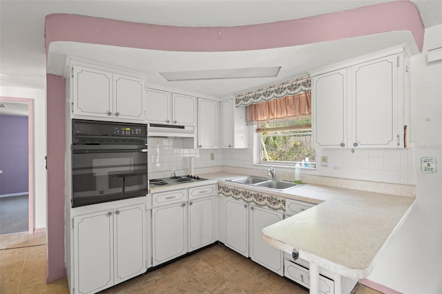 3348 Clydesdale Dr, Holiday, FL 34691 - kitchen featuring oven, a sink, white cabinets, under cabinet range hood, and light countertops