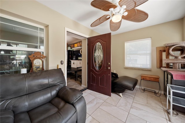 living room featuring ceiling fan and baseboards