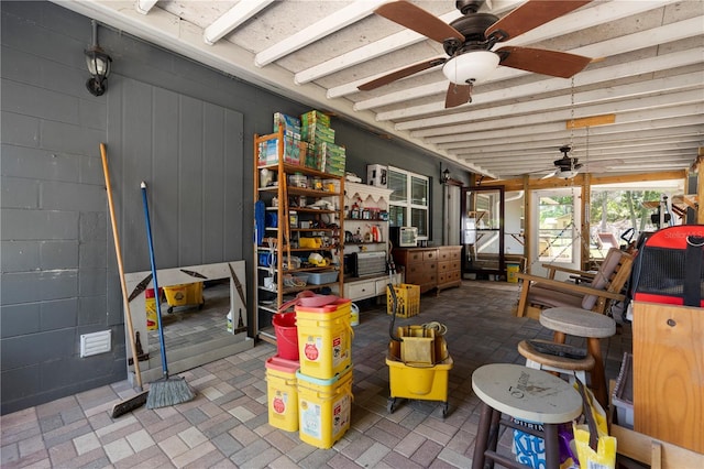 sunroom / solarium featuring ceiling fan and beamed ceiling