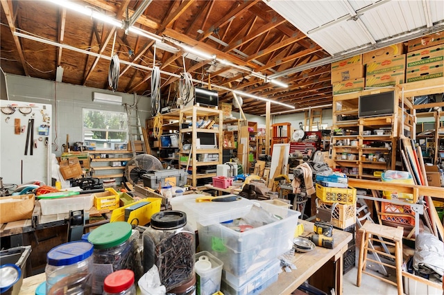 garage with white refrigerator, a workshop area, and concrete block wall
