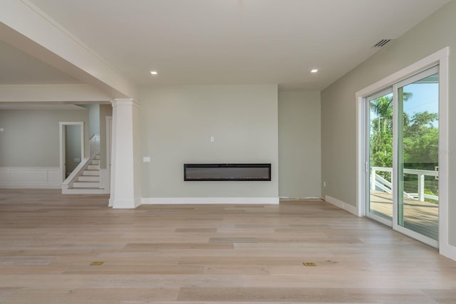 3752 Arkansas Ave NE, Saint Petersburg, FL 33703 - unfurnished living room featuring a glass covered fireplace, light wood-style floors, and recessed lighting