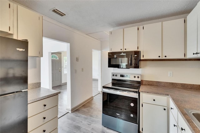 1920 E Chelsea St, Tampa, FL 33610 - kitchen featuring black microwave, freestanding refrigerator, stainless steel electric range, light wood finished floors, and a sink