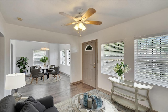 1920 E Chelsea St, Tampa, FL 33610 - living room with light wood finished floors, baseboards, a chandelier, and a ceiling fan