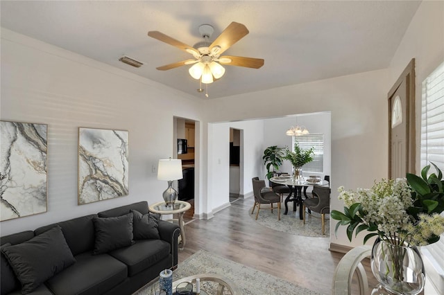 1920 E Chelsea St, Tampa, FL 33610 - living room with wood finished floors, ceiling fan, baseboards, and a chandelier