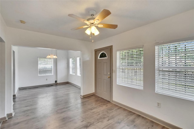 1920 E Chelsea St, Tampa, FL 33610 - foyer featuring light wood finished floors, baseboards, a ceiling fan, and a chandelier