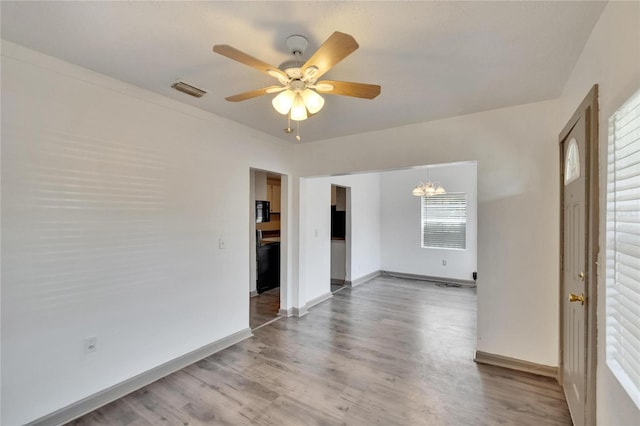 1920 E Chelsea St, Tampa, FL 33610 - unfurnished room featuring a chandelier, wood finished floors, a ceiling fan, and baseboards