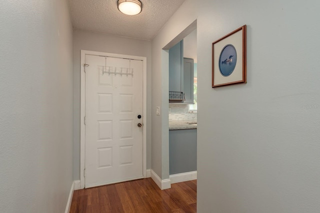 1065 Tartan Dr Unit C, Palm Harbor, FL 34684 - doorway to outside with dark wood-style flooring, a textured ceiling, and baseboards