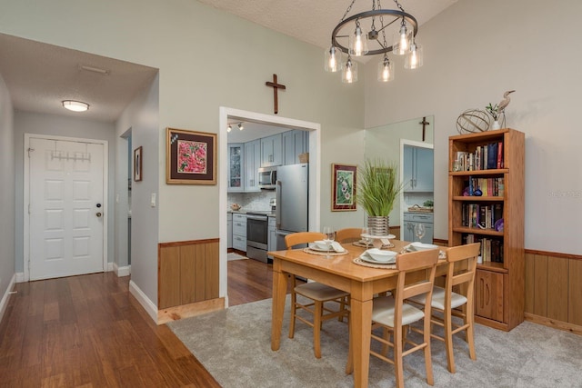 1065 Tartan Dr Unit C, Palm Harbor, FL 34684 - dining area featuring wood finished floors, a textured ceiling, baseboards, and wainscoting