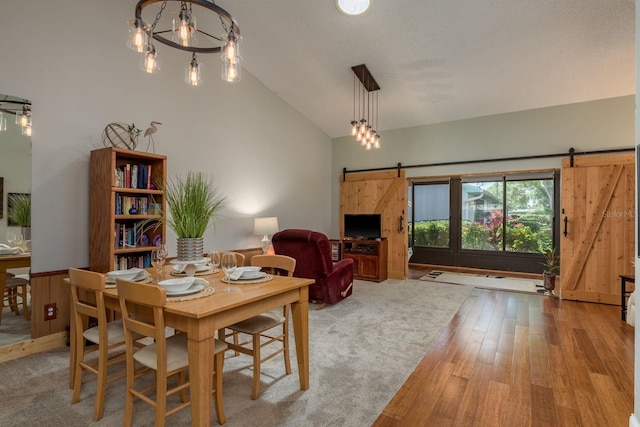 1065 Tartan Dr Unit C, Palm Harbor, FL 34684 - dining space with a barn door, lofted ceiling, and wood finished floors