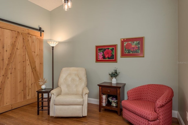 1065 Tartan Dr Unit C, Palm Harbor, FL 34684 - sitting room with baseboards, wood finished floors, and a barn door