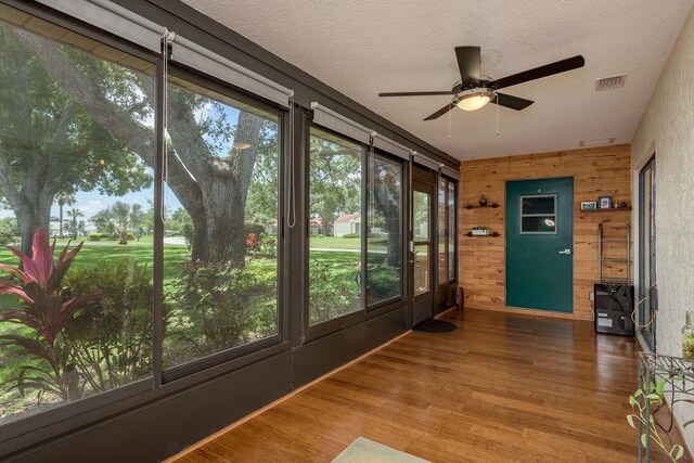 1065 Tartan Dr Unit C, Palm Harbor, FL 34684 - unfurnished sunroom with wood finished floors, a textured ceiling, and wood walls